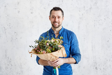 Man with a bouquet of roses. Pink roses  in the hands of a bearded man