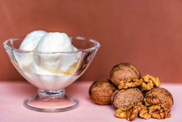 Vanilla ice cream in bowl and walnuts