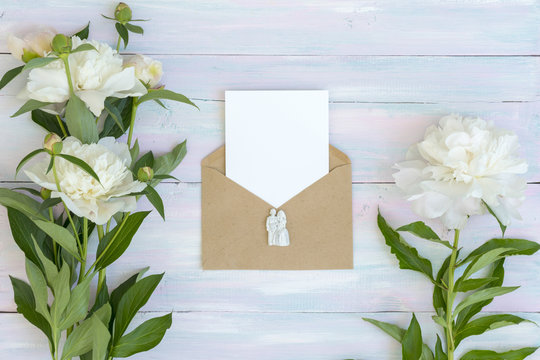 envelope and letter. Peonies on a wooden background. Texture. A photo for social networks. Flat lay desks