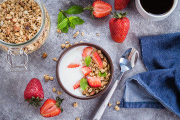 Flat-lay Food Concept. Yogurt, granola and strawberries on gray concrete table background. Top view. Healthy Food