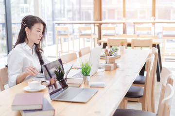 Happy asian business woman working with laptop in co-working.
