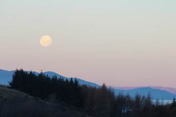 Red moon rising over the mountains