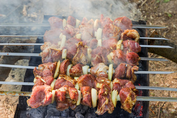 Shashlik during of cooking on the mangal outdoors