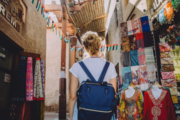 Back view of young female traveller at traditional bazaar in Dubai, UAE