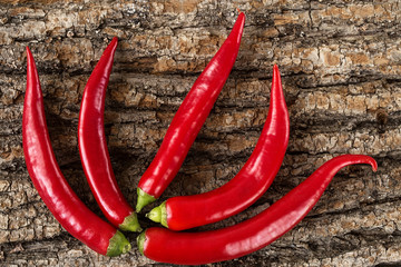 A pile of hot red pepper lying on a wooden background