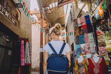 Back view of young female traveller at traditional bazaar in Dubai, UAE