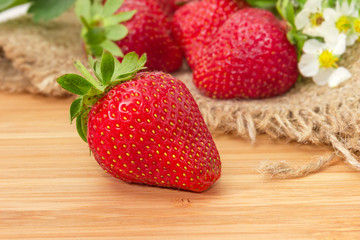 Garden strawberry closeup on blurred background of other berries