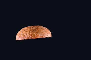 Grilled burger bun isolated on black background. Close up