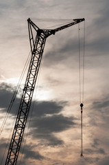 Industrial construction crane at sunset