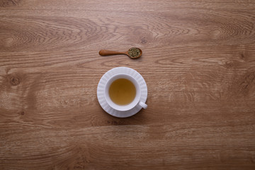 A glass of hot tea put on brown wood texture table.