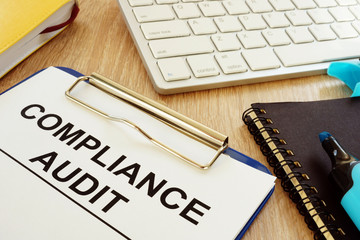 Compliance audit and documents on a desk.