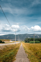 Fototapeta na wymiar Deserted Promenade Along An Asphalt Road Overlooking The Mountains And Clouds. Picturesque Landscape. Gelendzhik, Russia