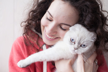 Fototapeta na wymiar Portrait of young beauty brunette holding gorgeous white cat. Woman love her cat. Family concept. Closed eyes