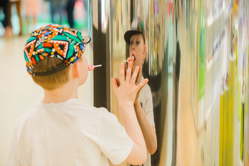 boy in holding hand on colorful abstract reflective surface
