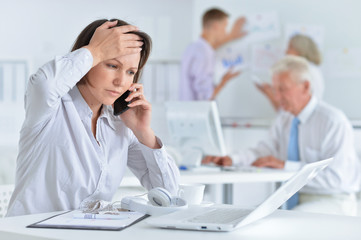 Fototapeta premium Young woman with headache working