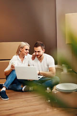 Happy Couple In New House Sitting On Floor 