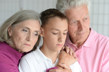 Sad senior grandparents with grandson