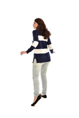full length portrait of girl wearing striped blue and white jumper and jeans. standing pose  facing away from the camera, on white studio background