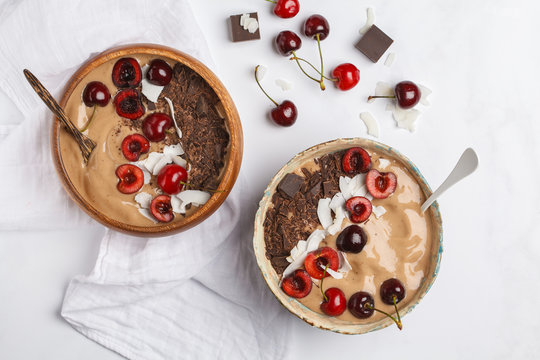 Chocolate - Cherry Smoothie Bowl With Coconut And Bananas On White Background, Top View. Healthy Vegan Food Concept.