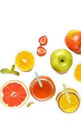 Multicolored fruit juices or smoothie in glass jars and ingredients. Top view, isolated on white background.