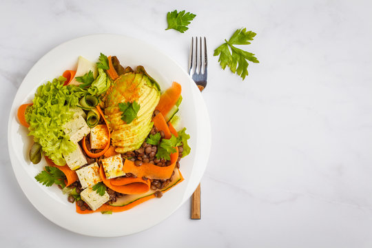 Vegan vegetables salad with lentils, avocado and tofu. Healthy vegan food concept.