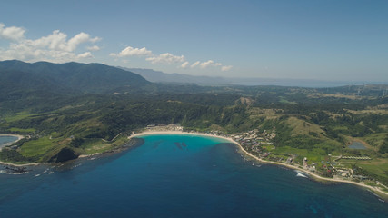 Fototapeta na wymiar Aerial view of beautiful tropical beach with turquoise water in blue lagoon, Pagudpud, Philippines. Ocean coastline with sandy beach. Tropical landscape in Asia.