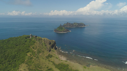 Obraz premium Aerial view of lighthouse in Palau island. Lighthouse in cape Engano against blue sky and rocky islands, province of Cagayan, Philippines.