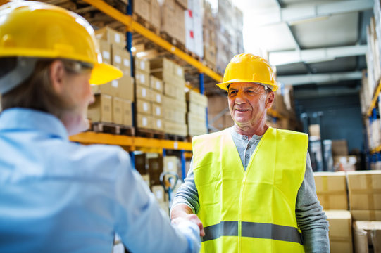 Senior woman manager and man worker working in a warehouse.