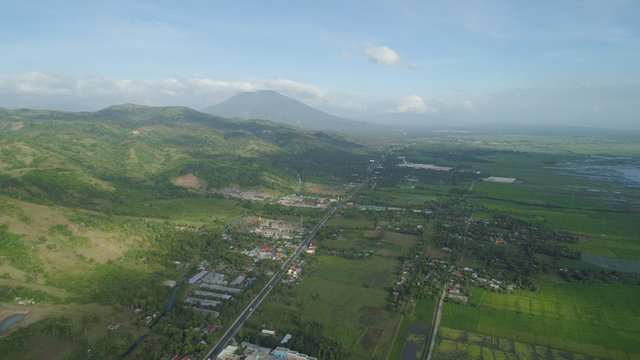 Aerial view of town in a mountain valley at the foot of the mountain Iriga. Luzon, Philippines. Mountainous tropical landscape.