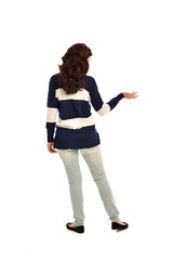 full length portrait of girl wearing striped blue and white jumper and jeans. standing pose  facing away from the camera, on white studio background