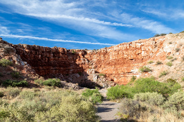 Fototapeta premium Carved out sinkhole with water fed from an Underground spring in the desert