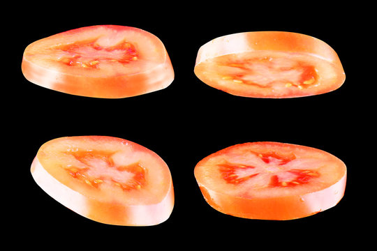 Sliced red tomato isolated on black background. Levity vegetable floating in the air