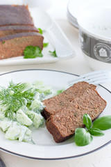 Snack plate with fresh salad from cucumbers and greens, pate from liver, selective focus