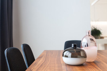 Decorative glass vases on wooden table in the kitchen