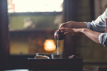 Women's hands pouring tea