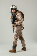 Soldier in camouflage holding rifle