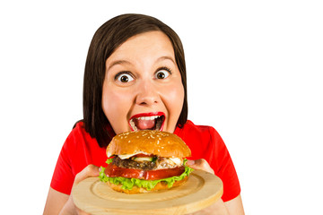 Young fat woman holds hamburger, smiles with opened mouth isolated on white background.