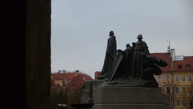Long shot of the Jan Hus Monument in Prague from behind a nearby pillar