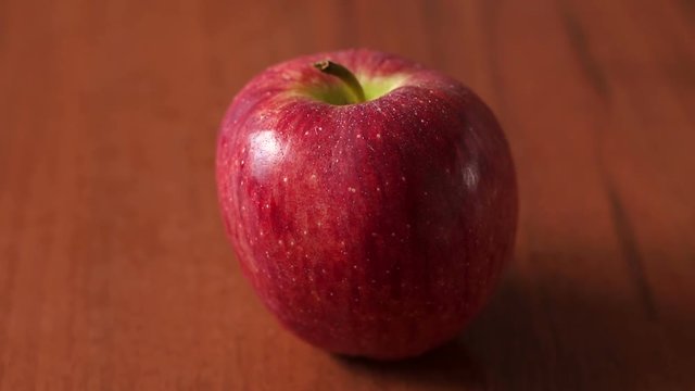 Red juicy ripe Apple on wooden brown background, close-up. Ripe fruit. Background. The concept of diet and healthy lifestyle.