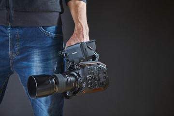 Kiev, Ukraine - April 22, 2018: Professional video man hand holding Video camera Panasonic AU-EVA1...