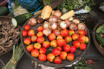 basket with different vegetable tomato onion pineapple at asian market