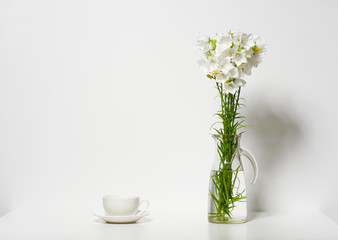Naklejka na ściany i meble bellflower and a cup in a vase on a table by the wall, white background