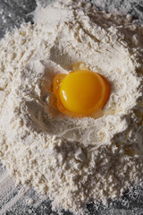 Raw egg and flour on the kitchen table, staged cooking dough