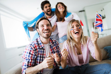 Soccer fans emotionally watching game in the living room.