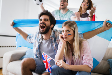 Happy and sad friends or football fans watching soccer game