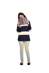 full length portrait of girl wearing striped blue and white jumper and jeans and holding a book. standing pose on white studio background