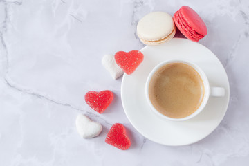 a cup of coffee with sweets on a gray marble background. Copy space. Selective focus.