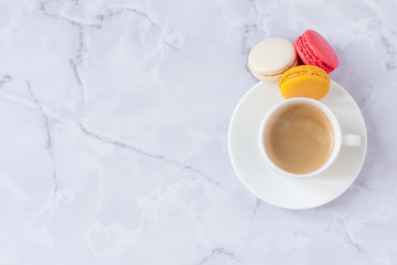 a cup of coffee with sweets on a gray marble background. Copy space. Selective focus.