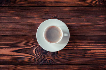 Cup of coffee on a wooden background. Copy space. Selective focus.