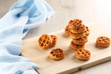 circle mini waffles on wooden cutting board